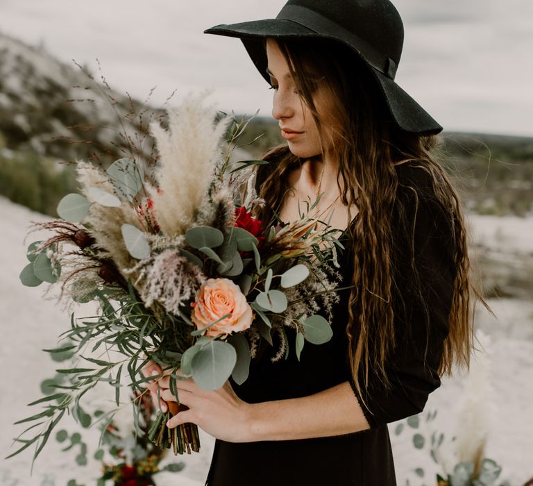 Bride in Portez Vos Idées Black Wedding Dress | Pampas Grass, Eucalyptus &amp; Red Rose Wedding Bouquet | Wild Same Sex Couple Wedding Inspiration Shoot | Anne Letournel Photography