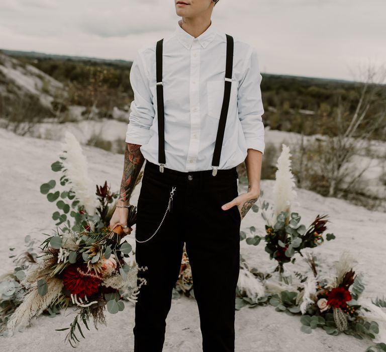 Bride in Trousers, White Shirt &amp; Braces | Pampas Grass, Eucalyptus &amp; Red Rose Wedding Bouquet | Horseshoe Pampas Grass, Eucalyptus &amp; Red Rose Floral Arrangement | Wild Same Sex Couple Wedding Inspiration Shoot | Anne Letournel Photography