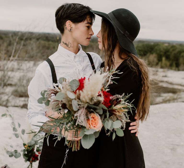 Bride in Portez Vos Idées Black Wedding Dress | Pampas Grass, Eucalyptus &amp; Red Rose Wedding Bouquet | Bride in Black Trousers, White Shirt &amp; Braces | Wild Same Sex Couple Wedding Inspiration Shoot | Anne Letournel Photography