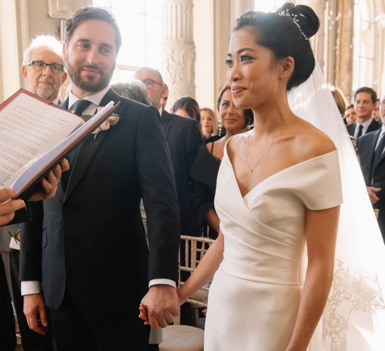 Bride and groom holding hands during wedding ceremony