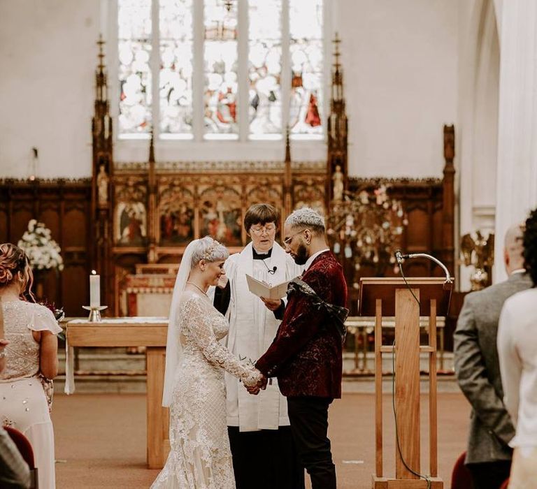 Bride and groom standing at the altar holding hands