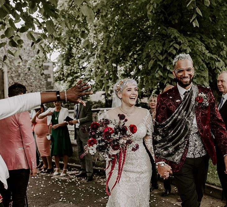 Stylish bride and groom confetti exit with bride in Lillian West wedding dress