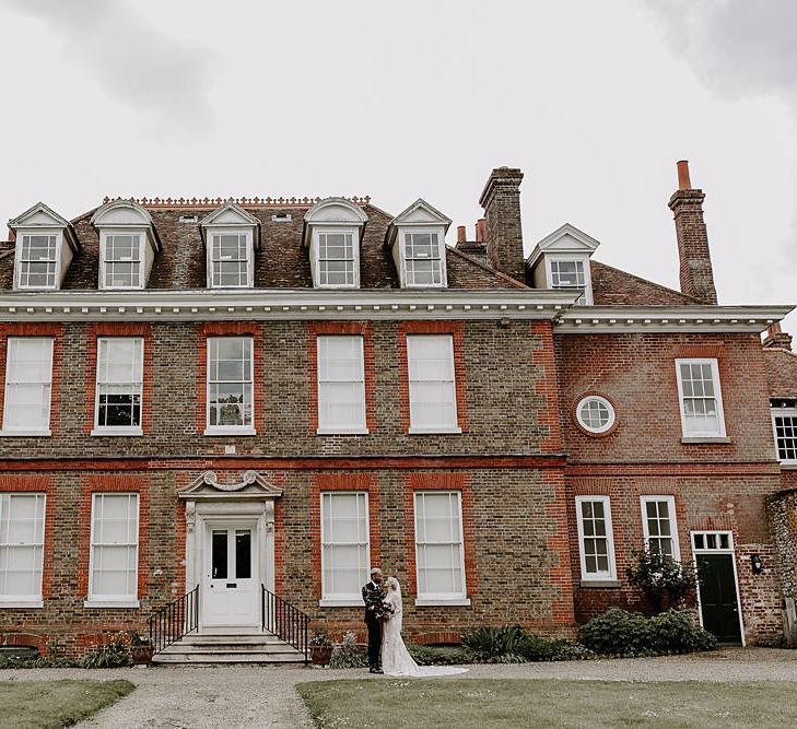 Bride and groom portrait outside their wedding venue Abbots Hall, Suffolk