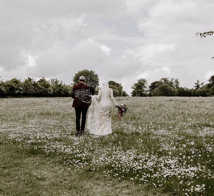 Bride and groom walking through the fields