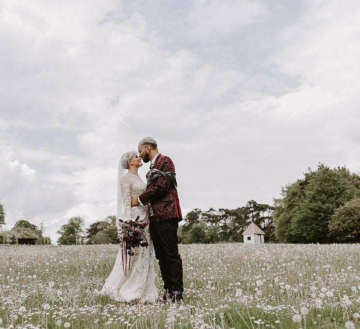 Stylish bride and groom portrait kissing in the fields