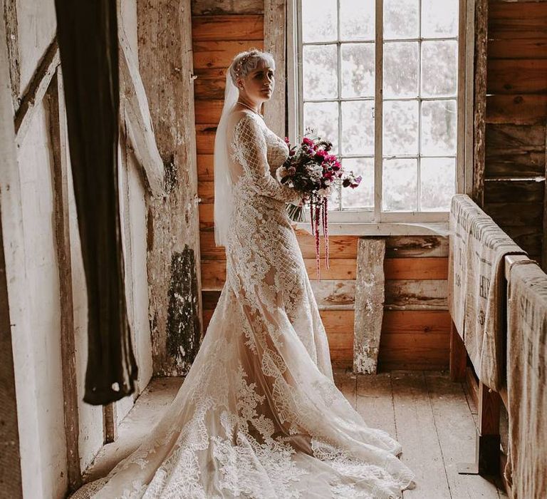 Bride in Lillian West wedding dress with illusion neckline and long sleeves