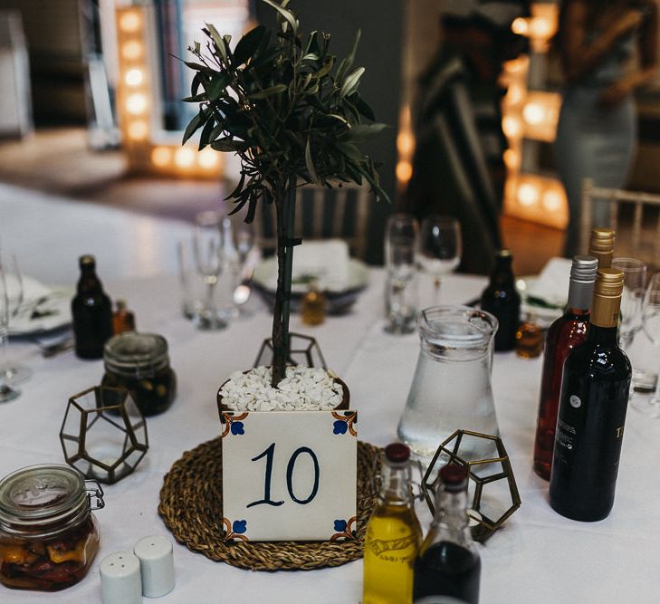 Table Styling | Mini Olive Tree in Terracotta Pot | Spanish Tile Table Number | Caramel Vodka Favours | Nottinghamshire Wedding with Spanish Vibes and Rewritten Bridesmaids Dresses | Kev Elkins Photography