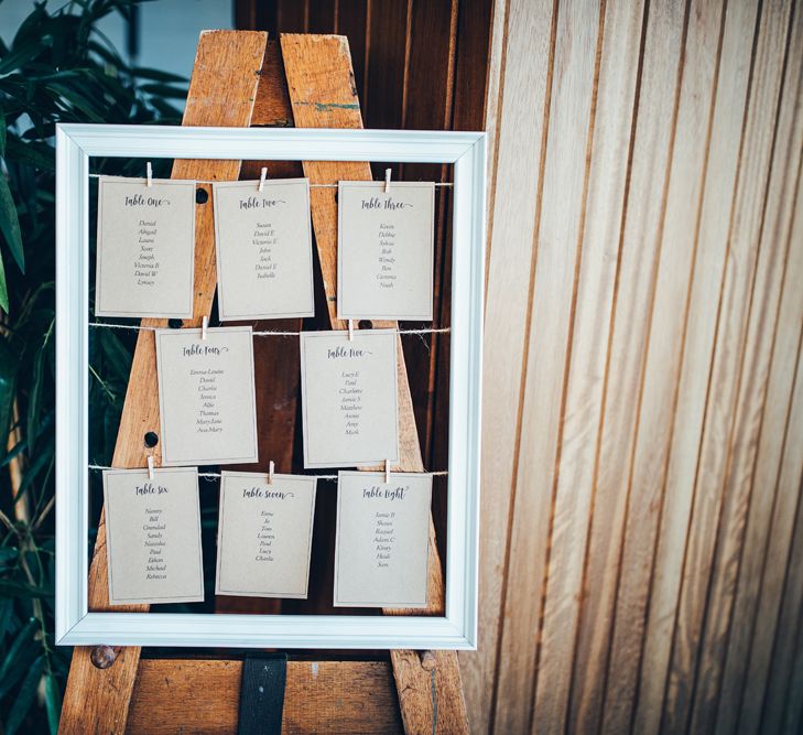 Wedding Reception Table Plan | Wooden Easel | White Picture Frame | Gypsophila Arch and Giant Balloons for an Outdoor Coastal Wedding | Toby Lowe Photography