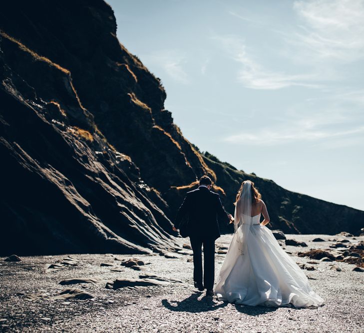 Bride in Strapless Ballgown Dress by Pronovias with Crystal Belt | Fingertip Veil | Groom in Navy Suit with Gypsophila Buttonhole | Gypsophila Arch and Giant Balloons for an Outdoor Coastal Wedding | Toby Lowe Photography