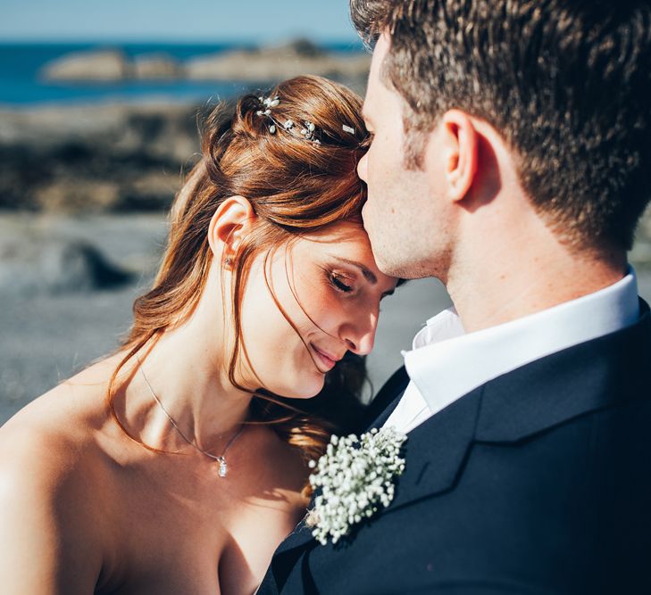 Bride in Strapless Ballgown Dress by Pronovias with Crystal Belt | Delicate Silver Hair Vine with Pearls and Crystals | Groom in Navy Suit with Gypsophila Buttonhole | Gypsophila Arch and Giant Balloons for an Outdoor Coastal Wedding | Toby Lowe Photography