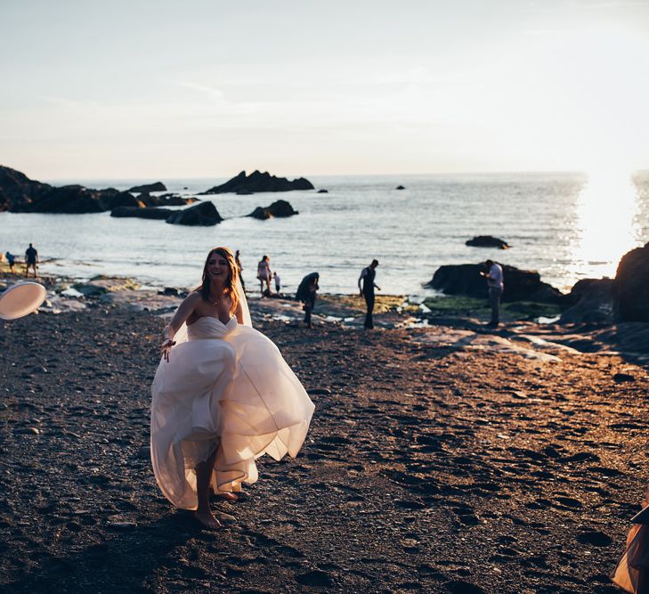 Bride in Strapless Ballgown Dress by Pronovias with Crystal Belt | Frisbee | Gypsophila Arch and Giant Balloons for an Outdoor Coastal Wedding | Toby Lowe Photography