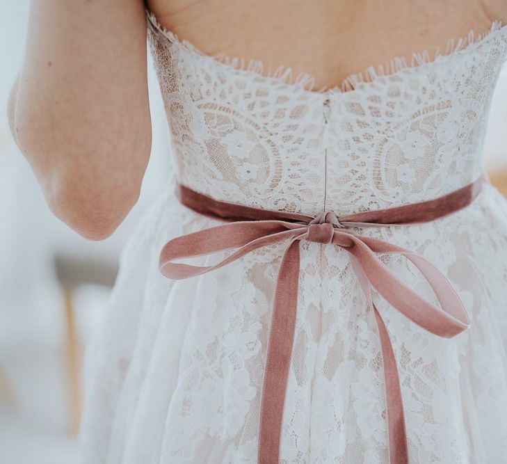 Back of brides delicate lace strapless  dress with ribbon detailing