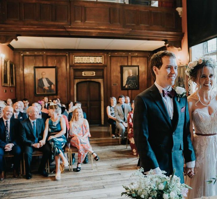 Intimate Oxford wedding ceremony with white flower decor and lace detailed dress