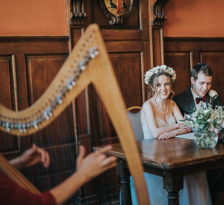 Bride and groom tie the knot at intimate civil ceremony with white bouquets and a harpist