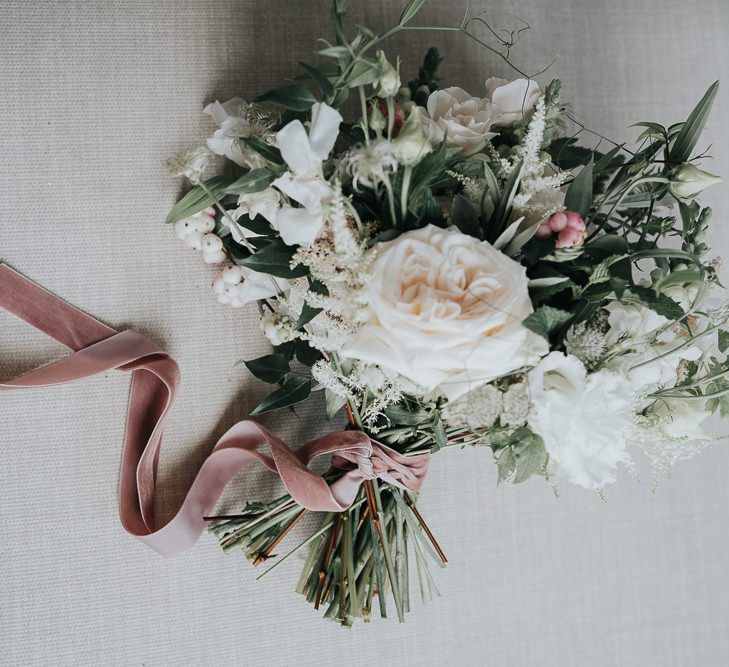 Beautiful white floral bouquet with ribbon detailing at relaxed celebration filled with personal touches