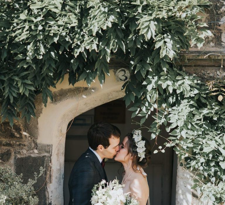 PopBride and groom tie the knot at intimate celebration with a white floral bouquet and a flower head crown