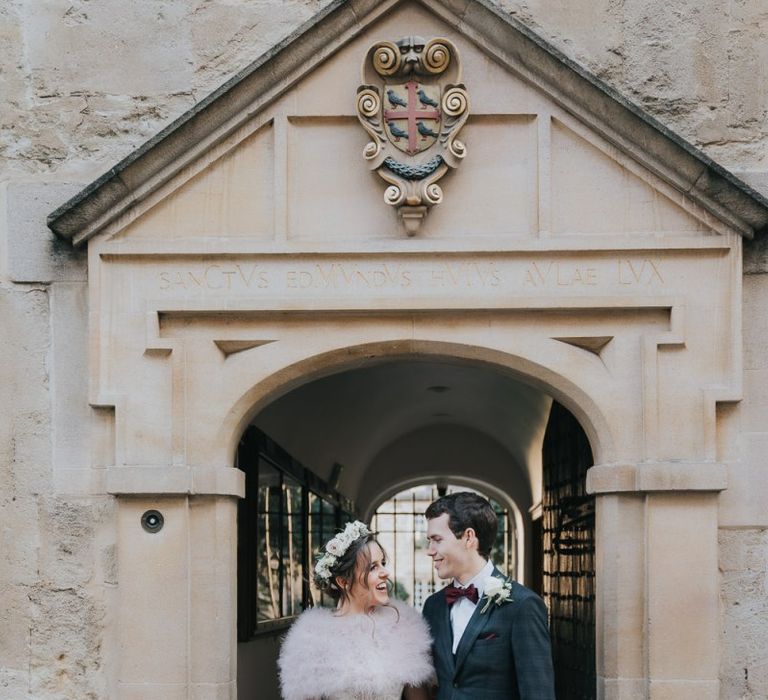 Bride and groom tie the knot at intimate celebration with a bridal shrug and a flower head crown