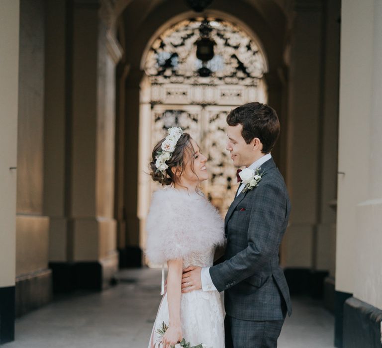 Bride and groom enjoy an intimate celebration with a bridal shrug and a beautiful white floral bouquet