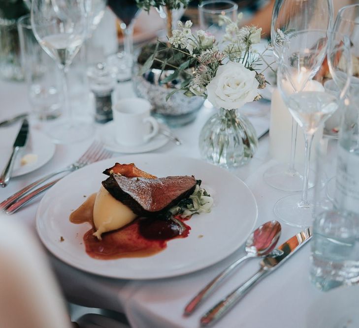 Food at the intimate and relaxed reception at Bodleian library with white floral centrepieces and candles