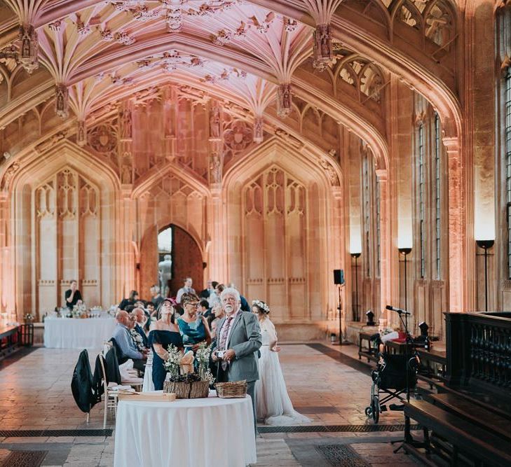 Guests enjoying an intimate and relaxed reception at Bodleian library with white floral centrepieces