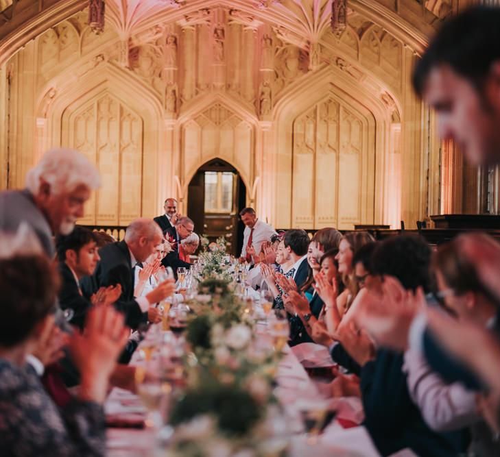 Guests enjoying an intimate and relaxed reception at Bodleian library with white floral centrepieces and stunning backdrop