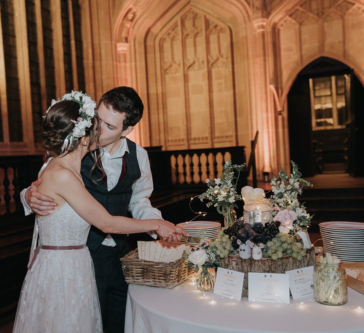 Bride and groom cutting the cheese tower cake at intimate celebration