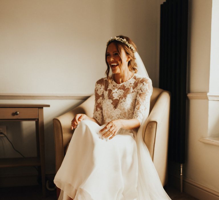 Bride in lace sleeved wedding dress with flower crown and pink shoes