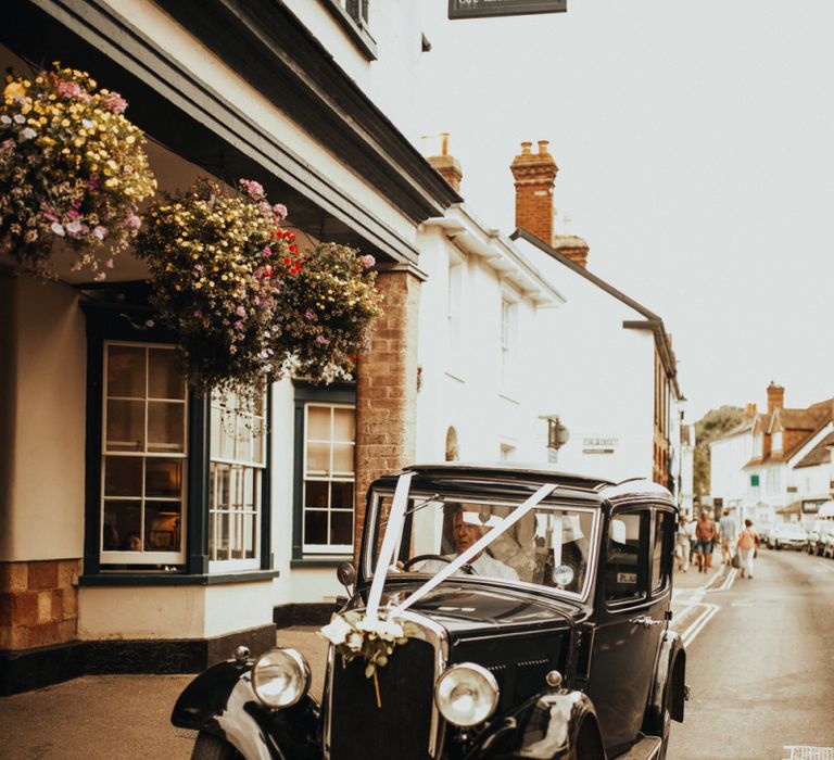 Vintage wedding car for Devonshire wedding  with floral chandelier and foliage table runner