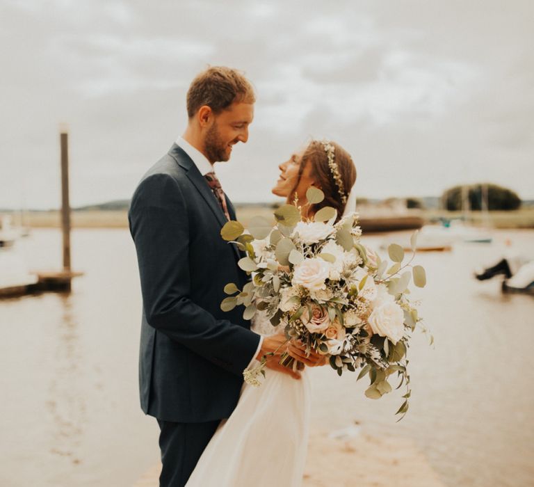 Large bridal bouquet at wedding with foliage table runner