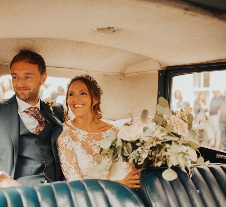 Bride and groom in vintage wedding car