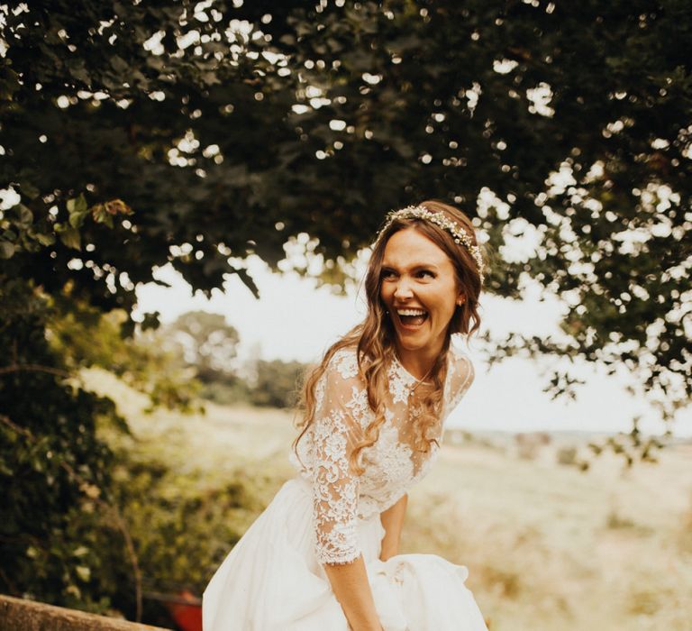 Bride in long sleeved wedding dress at flower and foliage themed day