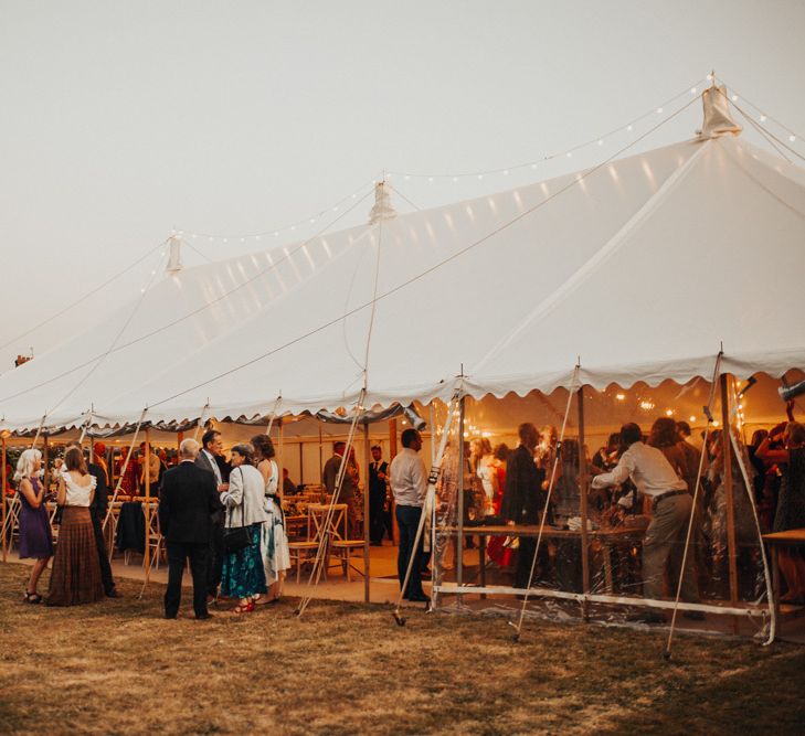 Marquee reception with floral chandelier and foliage table runner