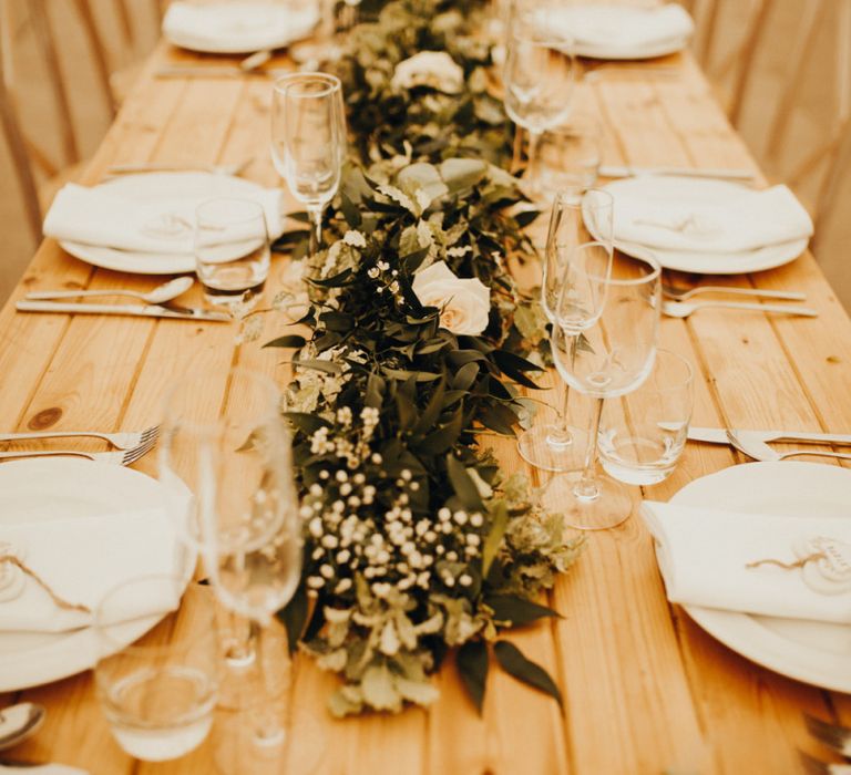 Foliage table runner with flowers on trestle tables