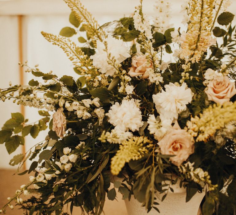 Beautiful floral displays at marquee wedding with foliage table runner