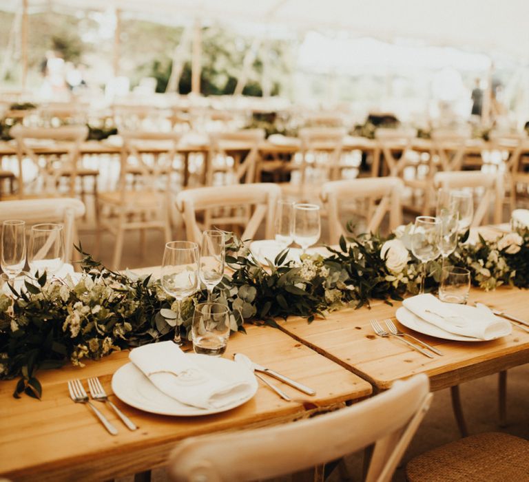 Beautiful marquee wedding decor with foliage table runners