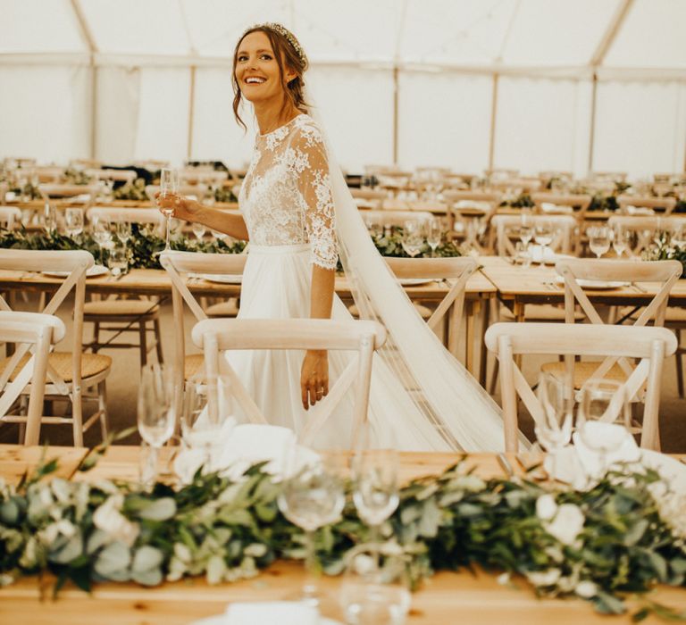 Bride sees marquee wedding decor and foliage table runners