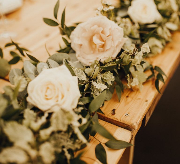 Wedding flowers amongst foliage table runner