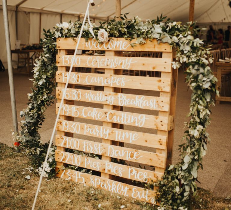 Wooden pallet sign with foliage and flower garland decor