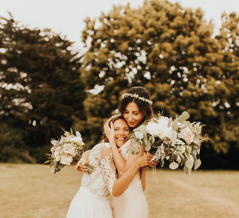 Bride with bridesmaid in pink dress and flower crown