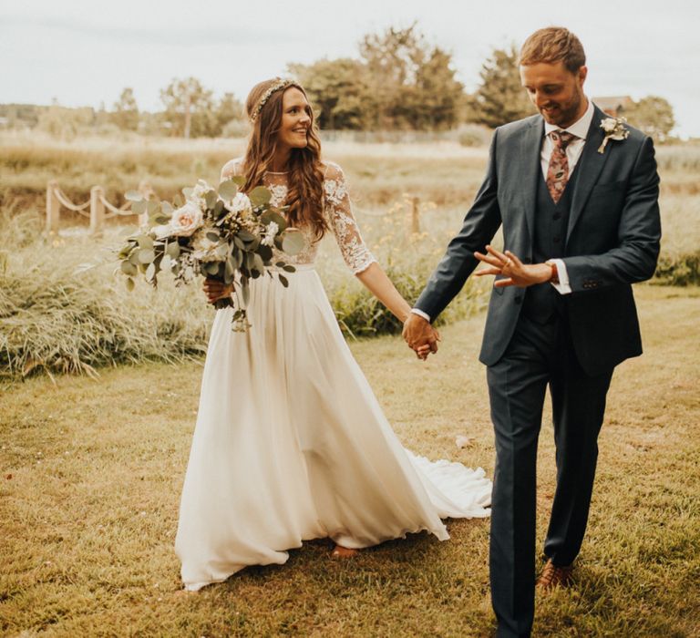 Bride and groom stroll through family garden