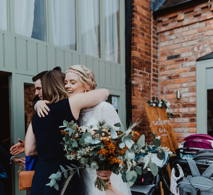 Happy Bride in Jewel Headdress Hugging Wedding Guest