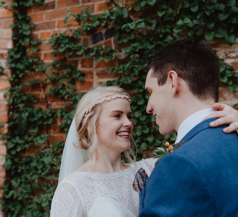 Bride in Jewelled Headdress and Groom in Blue Hugo Boss Suit Embracing