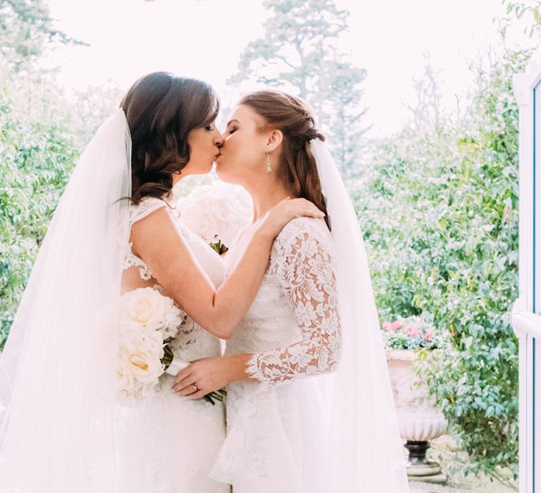 Two Brides in Lace Wedding Dresses Kissing