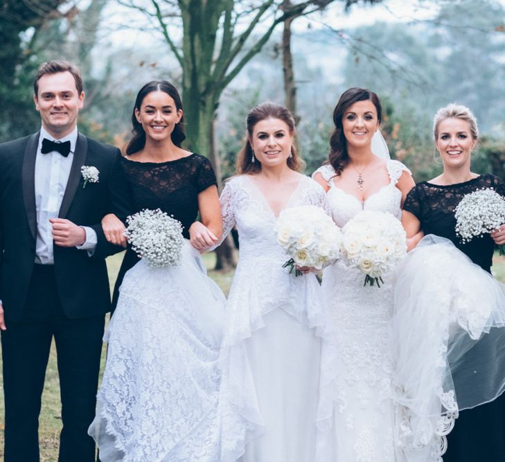 Wedding Party Portrait with Black Tie Suits and Two Bride in Alice Temperley and Essense of Australia Lace Wedding Dresses