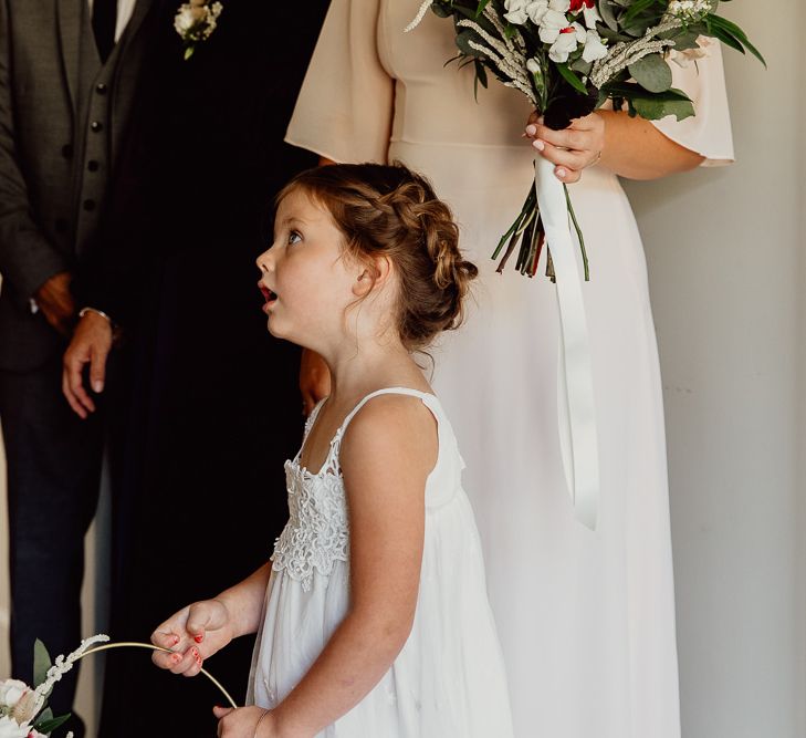 Flower girl in white dress at Norfolk barn wedding