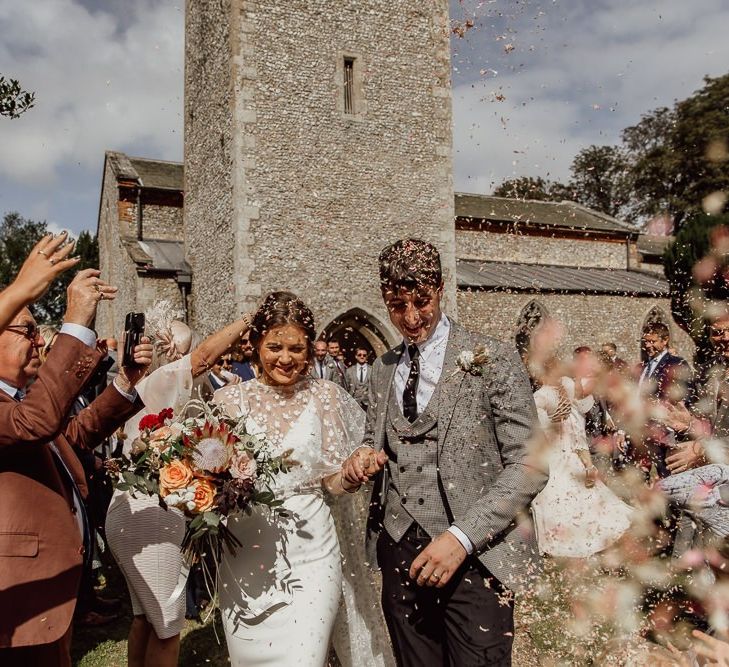 Confetti exit for bride and groom after church ceremony