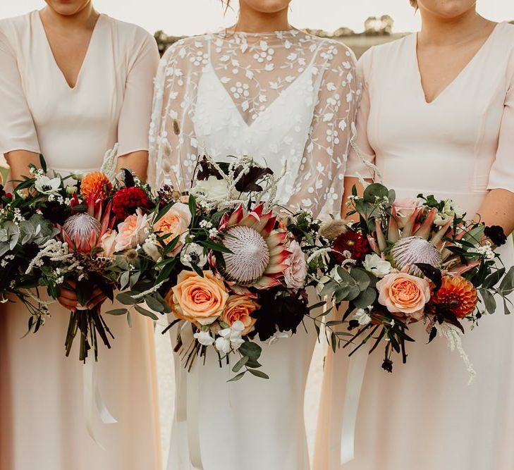 Stunning coral  bouquets with King Protea flowers