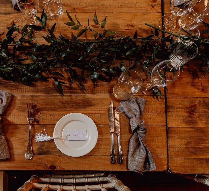 Foliage and candles on trestle tables at Norfolk barn wedding