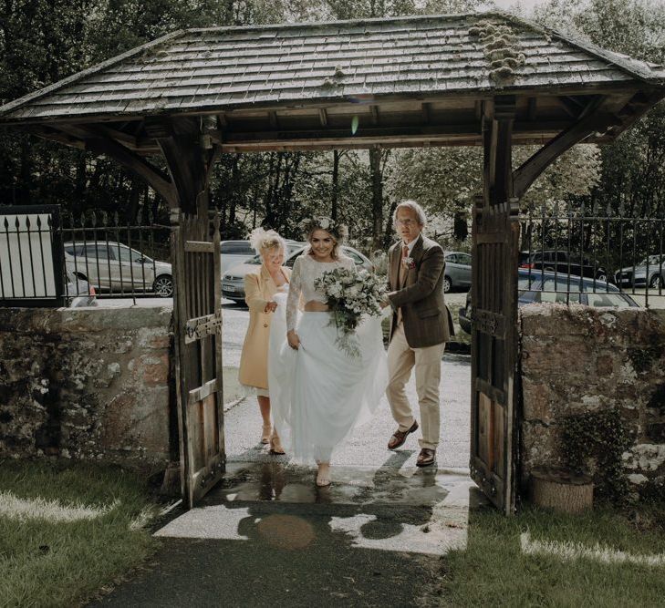 Bride arriving at the church with her family wearing two piece bridal gown