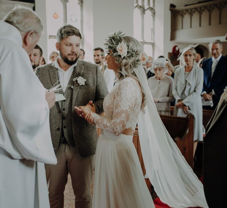 Bride wearing two piece bridal dress and groom in relaxed suit with floral button hole